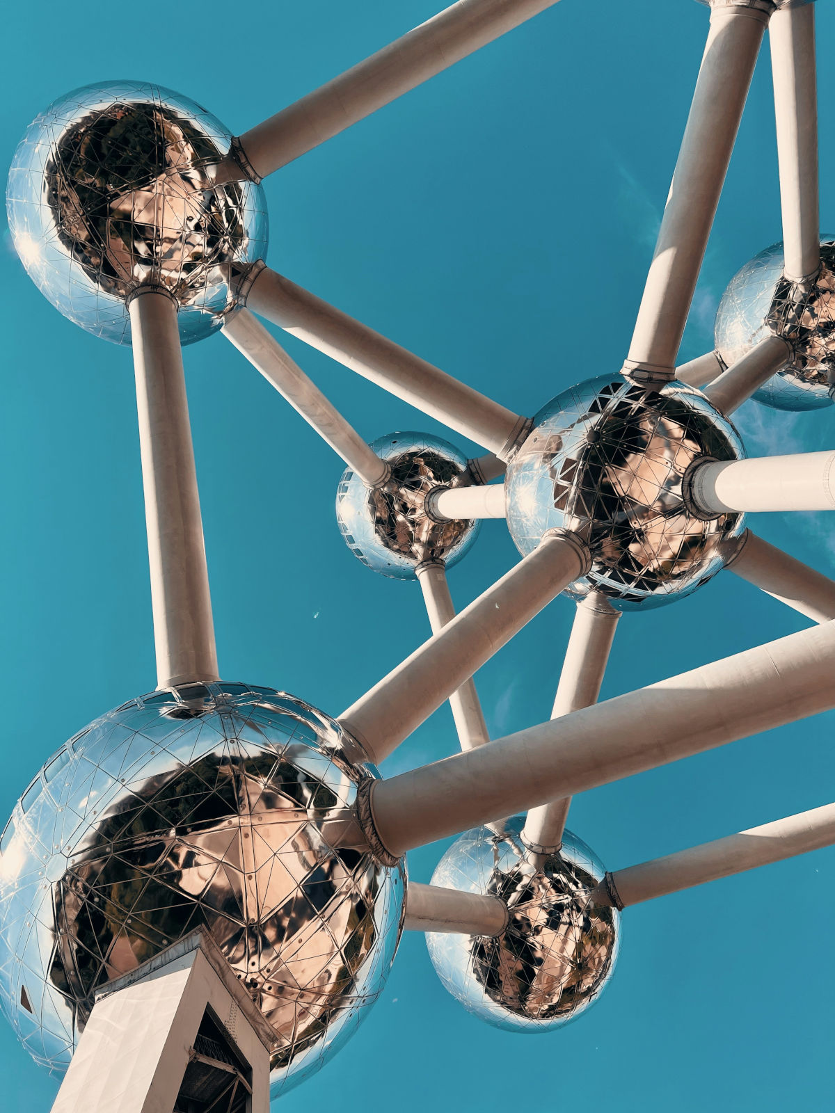 Photo of a part of the Atomium in Brussels. A blue sky with shiny silver balls connected with each other